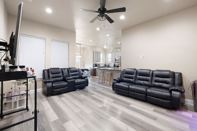 living room with ceiling fan and light hardwood / wood-style floors