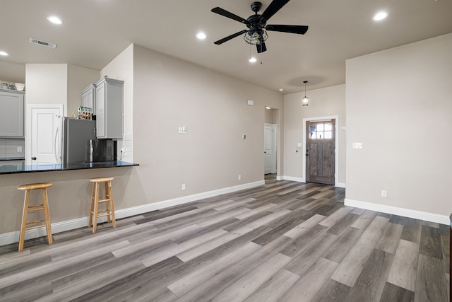 unfurnished living room with light hardwood / wood-style flooring and ceiling fan