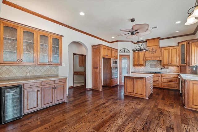 kitchen featuring a center island, wine cooler, dark hardwood / wood-style flooring, decorative light fixtures, and appliances with stainless steel finishes