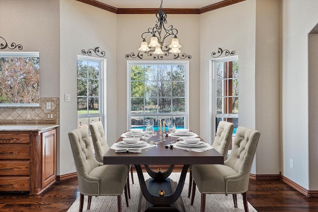 dining room with dark hardwood / wood-style flooring, crown molding, and a chandelier