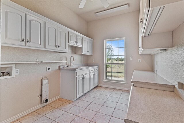 kitchen featuring white cabinets, ceiling fan, light tile patterned floors, and sink