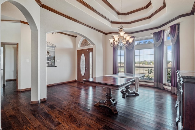 game room with crown molding, a tray ceiling, dark hardwood / wood-style floors, and a chandelier