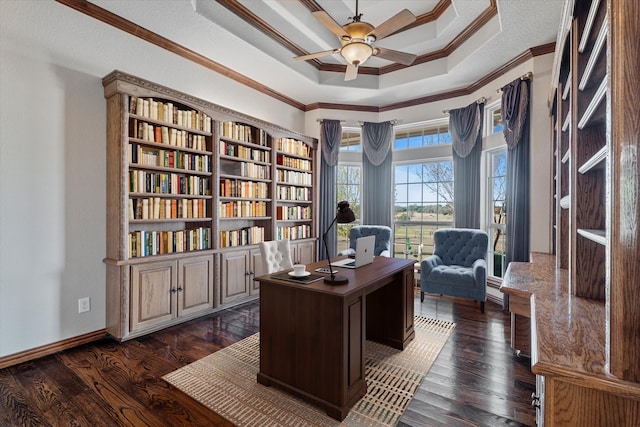 office space with dark wood-type flooring, ceiling fan, crown molding, and a raised ceiling