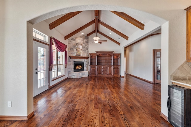 unfurnished living room featuring beamed ceiling, dark hardwood / wood-style floors, wine cooler, and a fireplace