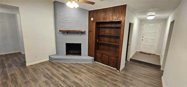 unfurnished living room with a textured ceiling, ceiling fan, a fireplace, and dark hardwood / wood-style floors