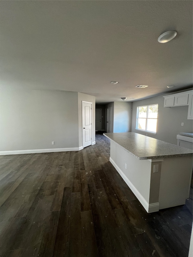 kitchen featuring white cabinetry, dark hardwood / wood-style flooring, and a center island