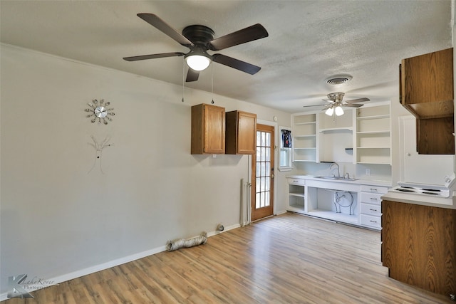 kitchen with sink, light hardwood / wood-style flooring, and a textured ceiling