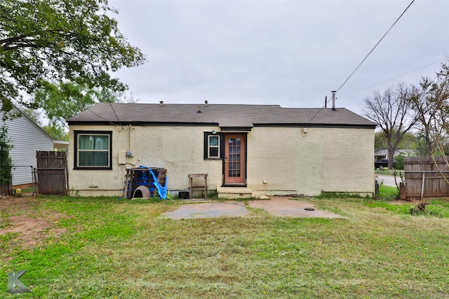 back of house with a lawn