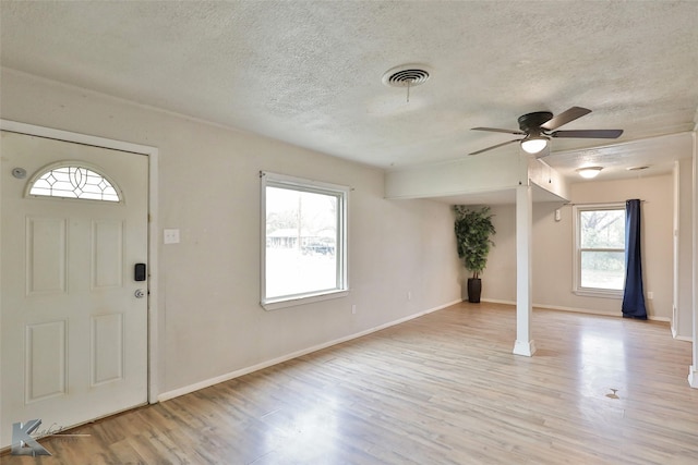 entrance foyer with ceiling fan, a textured ceiling, and light wood-type flooring