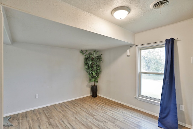 empty room featuring light hardwood / wood-style flooring and a textured ceiling