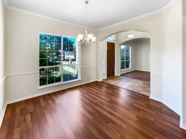 unfurnished dining area with hardwood / wood-style floors, ornamental molding, and a notable chandelier