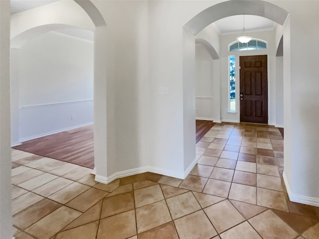 foyer featuring light wood-type flooring and crown molding