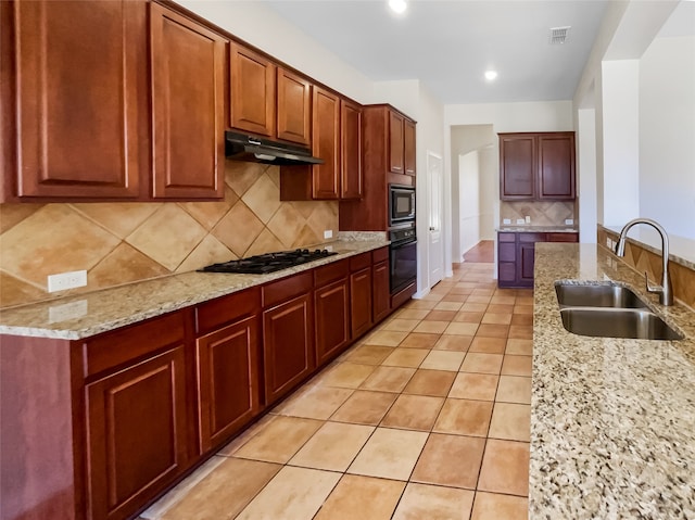 kitchen with light stone countertops, sink, decorative backsplash, light tile patterned flooring, and black appliances