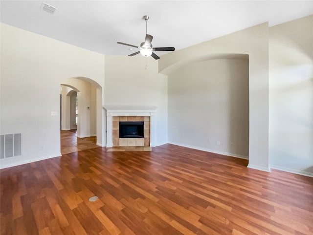 unfurnished living room with hardwood / wood-style flooring, ceiling fan, and a tile fireplace