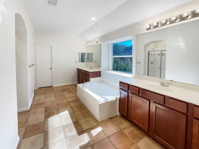 bathroom with tile patterned floors, vanity, lofted ceiling, and plus walk in shower