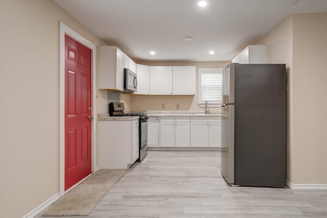 kitchen featuring light hardwood / wood-style floors, white cabinetry, sink, and appliances with stainless steel finishes