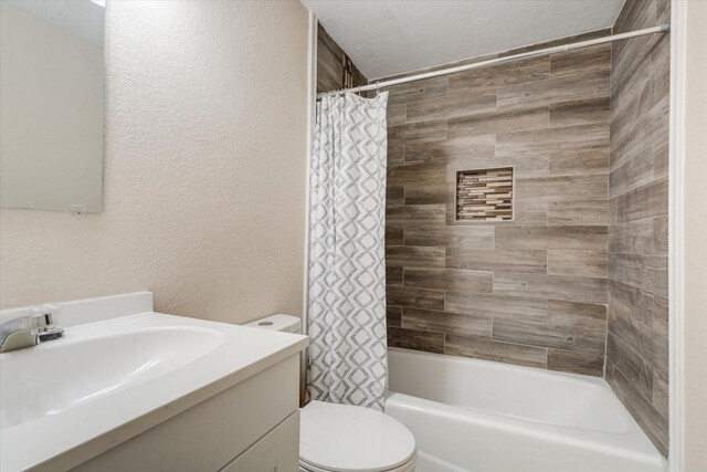 full bathroom with vanity, toilet, shower / bath combo, and a textured ceiling