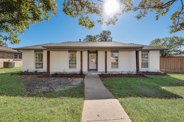 view of front of home featuring central AC unit, covered porch, and a front yard