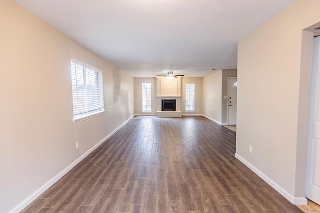 unfurnished living room featuring dark wood-type flooring, a fireplace, and ceiling fan