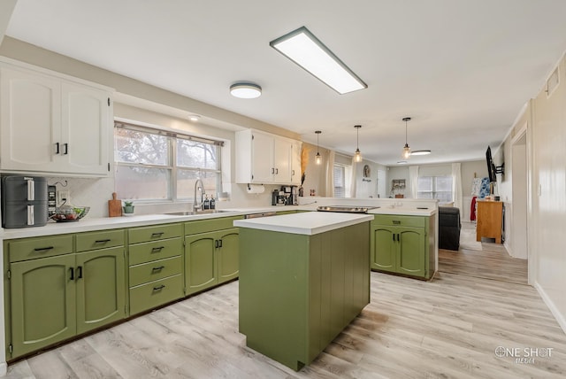 kitchen with pendant lighting, sink, white cabinetry, a kitchen island, and kitchen peninsula