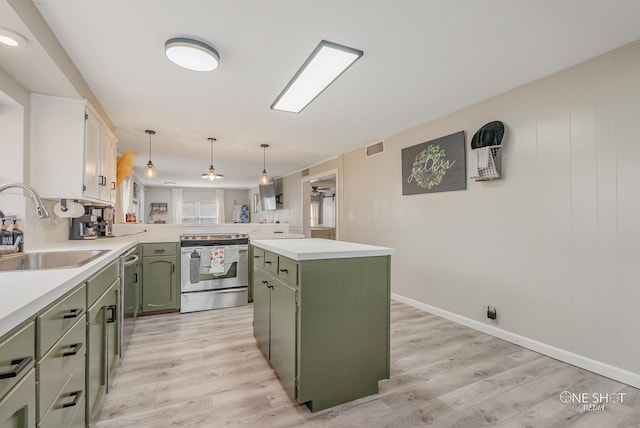 kitchen with a center island, sink, stainless steel appliances, and green cabinetry