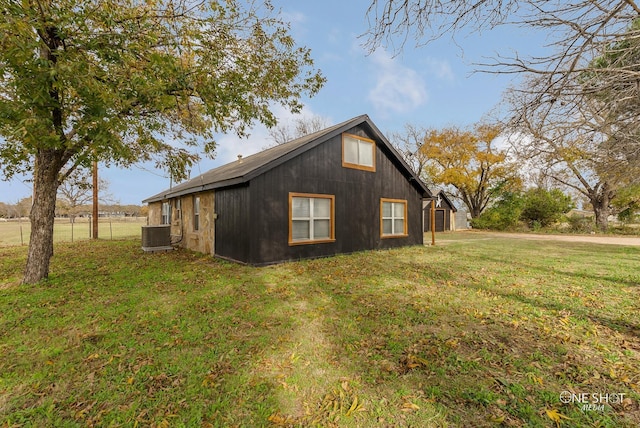 view of home's exterior with central AC and a yard