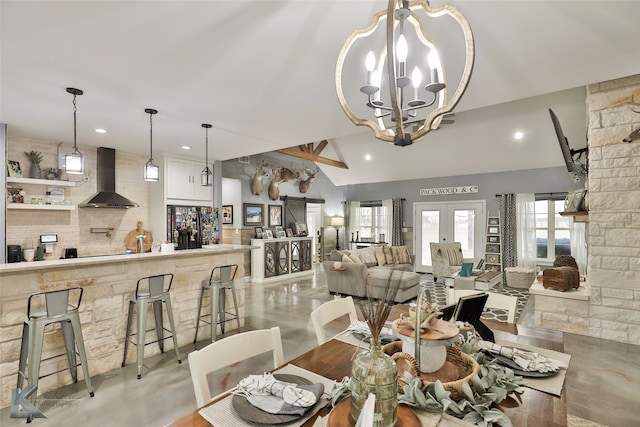 dining space with a chandelier, french doors, and vaulted ceiling with beams