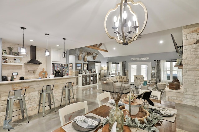 dining space with french doors, lofted ceiling, and a notable chandelier