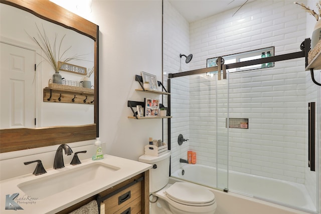 full bathroom with vanity, shower / bath combination with glass door, and toilet