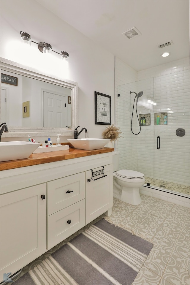 bathroom featuring vanity, an enclosed shower, and toilet