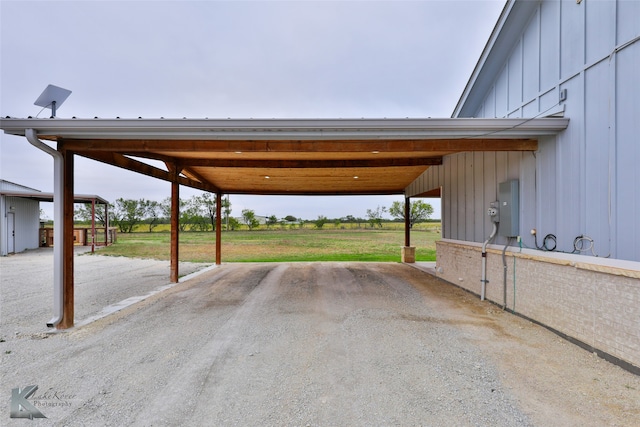 view of parking / parking lot with a carport and a lawn