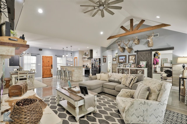 living room featuring ceiling fan, a barn door, washer / dryer, and high vaulted ceiling