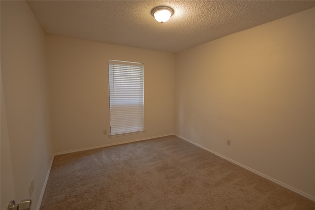 carpeted spare room featuring a textured ceiling