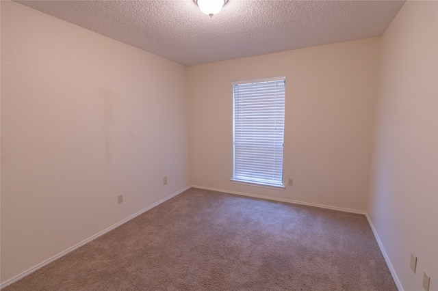 unfurnished room featuring carpet and a textured ceiling