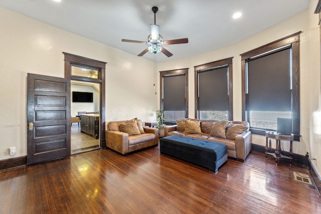 living area featuring ceiling fan, visible vents, baseboards, and hardwood / wood-style floors