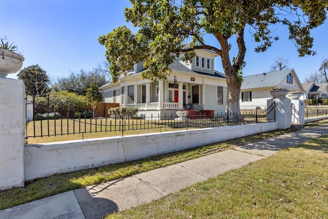 bungalow featuring covered porch, a fenced front yard, and a front yard