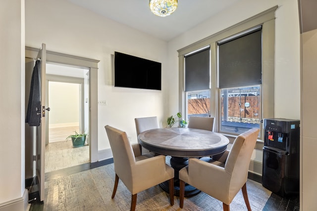 dining area with baseboards and wood finished floors