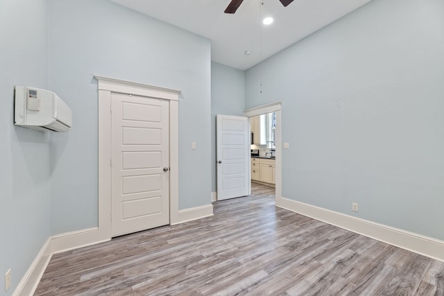 unfurnished bedroom with light wood-type flooring, a ceiling fan, and baseboards