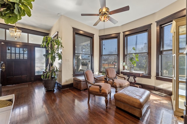 foyer with ceiling fan with notable chandelier, wood-type flooring, a wealth of natural light, and baseboards