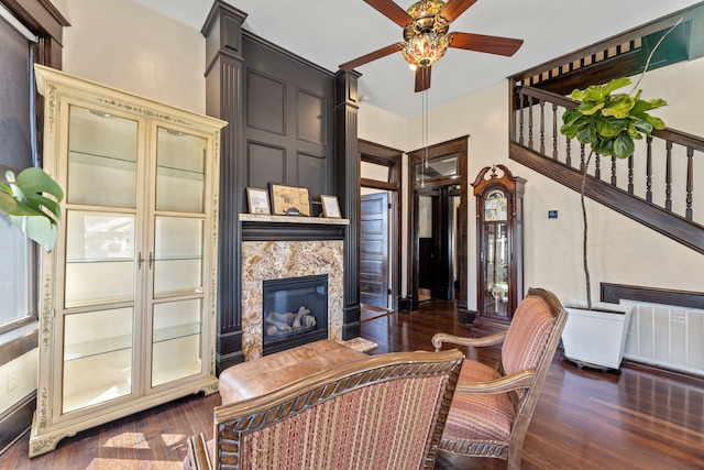 living room with a ceiling fan, wood finished floors, and a premium fireplace