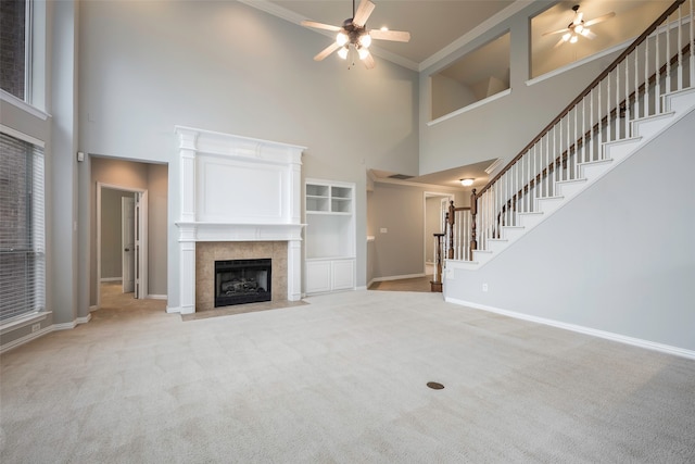 unfurnished living room featuring a high ceiling, light colored carpet, and ceiling fan