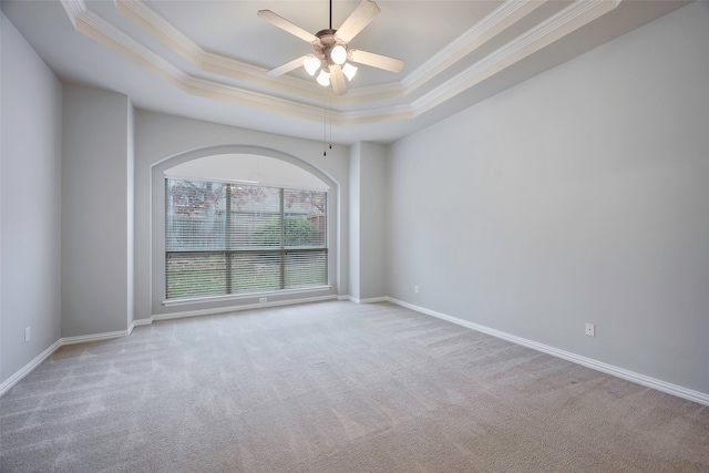 unfurnished room featuring light carpet, a tray ceiling, and ornamental molding