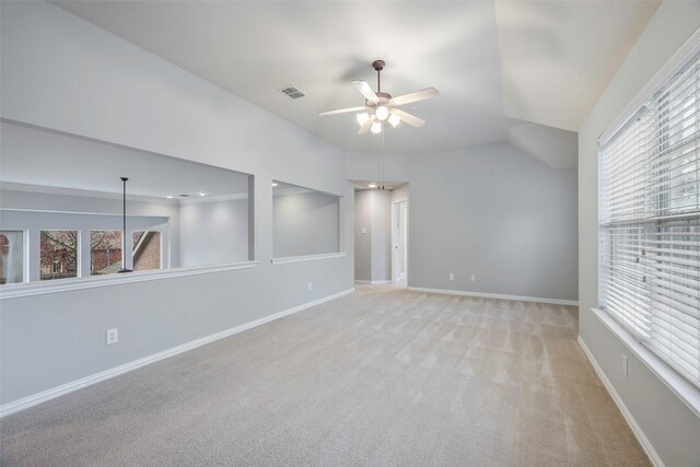 spare room with ceiling fan, a healthy amount of sunlight, and light carpet