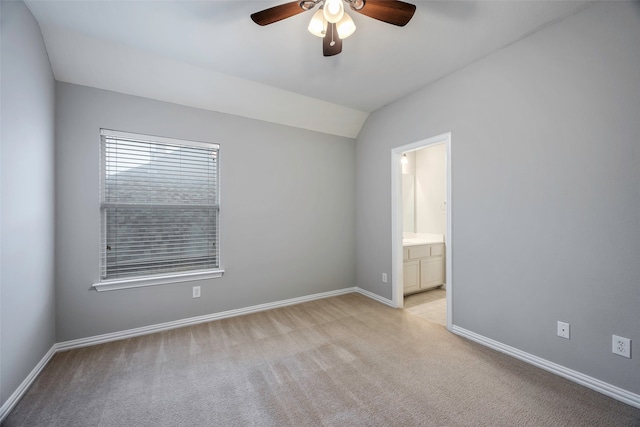 carpeted empty room with ceiling fan and vaulted ceiling