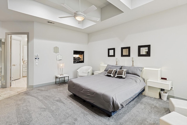 bedroom featuring a high ceiling, light colored carpet, and ceiling fan