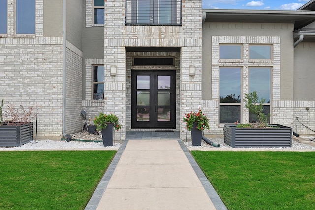 entrance to property with a yard and french doors