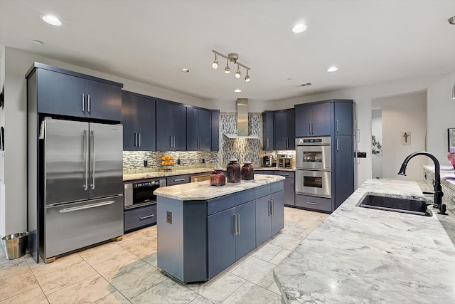 kitchen with a center island, sink, wall chimney exhaust hood, decorative backsplash, and stainless steel appliances