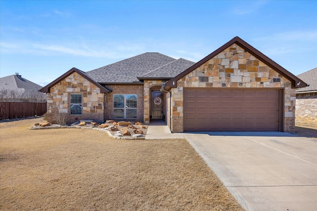 view of front of house featuring brick siding, a shingled roof, an attached garage, fence, and driveway