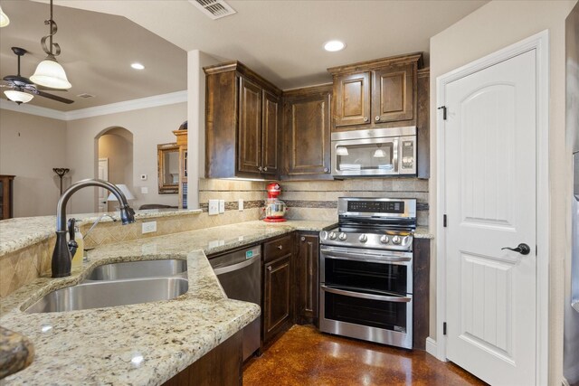 kitchen featuring kitchen peninsula, a breakfast bar, stainless steel appliances, sink, and pendant lighting