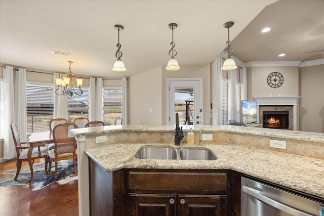 kitchen featuring light stone counters, stainless steel dishwasher, a sink, and visible vents